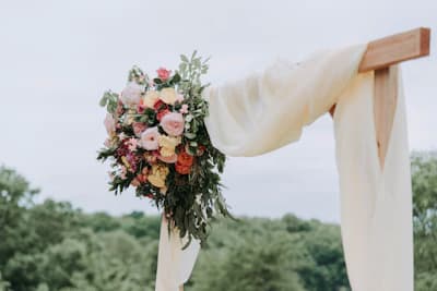 Joyful wedding guests capturing candid photos on smartphones at a scenic outdoor ceremony reception