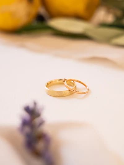 Close-up of elegant wedding rings resting on delicate lace fabric with soft warm lighting